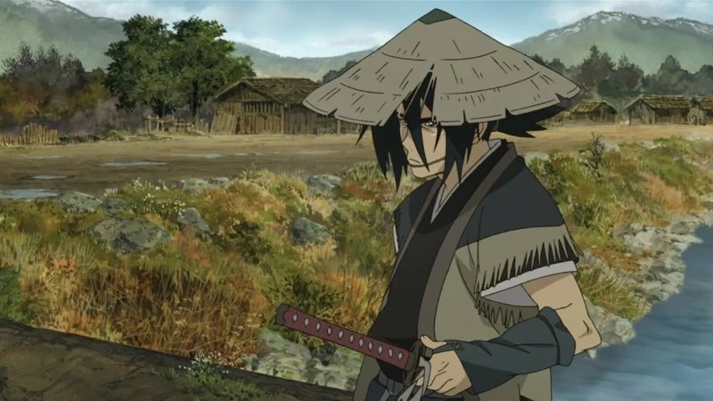 A wandering swordsman, identified as Nanashi from the anime movie Sword of the Stranger, stands by a body of water in a rural village setting. He has dark, spiky hair, a straw hat, and wears traditional Japanese clothing. A sheathed katana is visible at his waist. The background features simple wooden structures and mountains. 