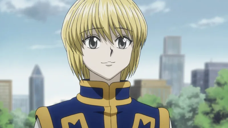 A portrait shot of the anime character Kurapika from Hunter x Hunter. The character has short blond hair and light-colored eyes, and is wearing a blue and yellow tunic. The background is a blurred outdoor scene with buildings and trees.