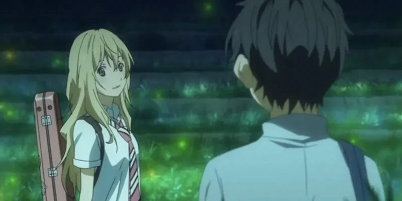 A young woman with blonde hair, identified as Kaori Miyazono, smiles at a young man with dark hair, identified as Kousei Arima, who has his back to the viewer. Kaori holds a violin case, and they are standing on steps in an outdoor, dimly lit setting with glowing green lights around them. 
