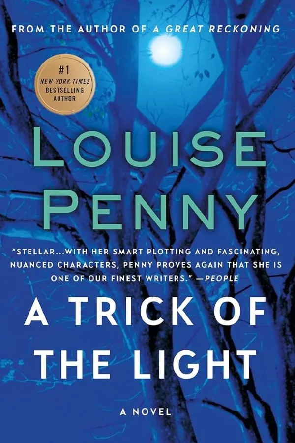 Description: Book cover for "A Trick of the Light" by #1 New York Times Bestselling Author Louise Penny. Visuals: The background is a dark blue night scene with bare tree branches silhouetted against a bright full moon. Text: Text on the cover includes the author's name, the book title, a quote from People magazine, and a note that it is "A Novel".