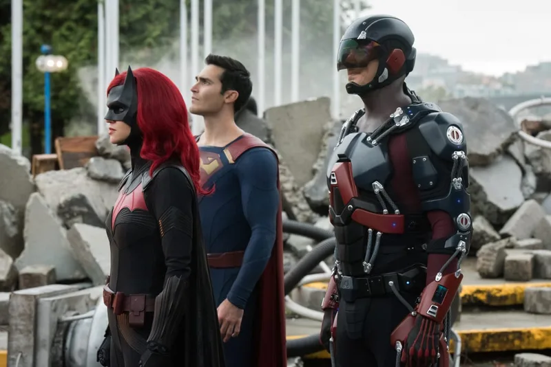 Ruby Rose as Batwoman, Tyler Hoechlin as Superman, and Brandon Routh as The Atom standing together in a rubble-filled area.