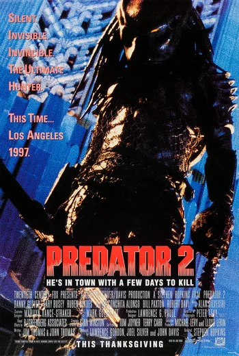 A movie poster for "Predator 2" featuring the creature standing over a city, with text that reads "SILENT INVISIBLE INVINCIBLE THE ULTIMATE HUNTER", "THIS TIME... LOS ANGELES 1997", and "PREDATOR 2 HE'S IN TOWN WITH A FEW DAYS TO KILL"